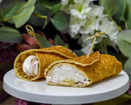 Crepe roll ups filled with whipped cream, banana, strawberry compote (v)